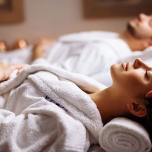 happy young beautiful couple enjoying head massage at the spa
