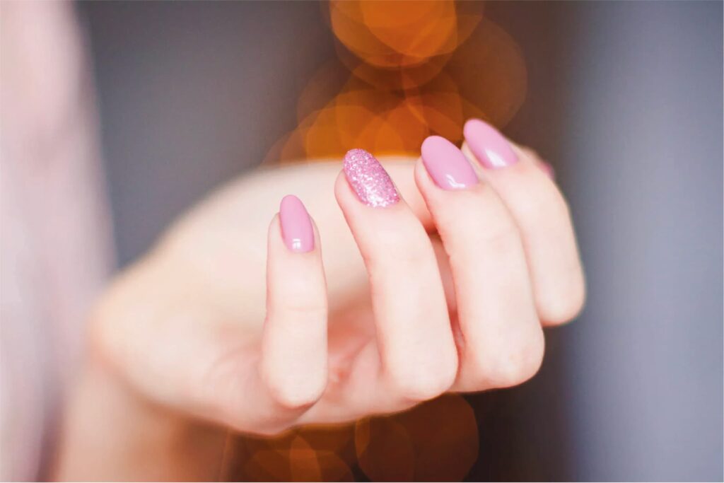 Close-up view of beautifully manicured nails with a glossy finish, showcasing a vibrant color palette and intricate nail art design